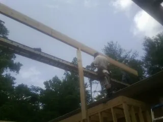 Carpenter setting a ridge beam over a new addition frame — Ice Dam Removal by Roofing Brothers in New Woodstock