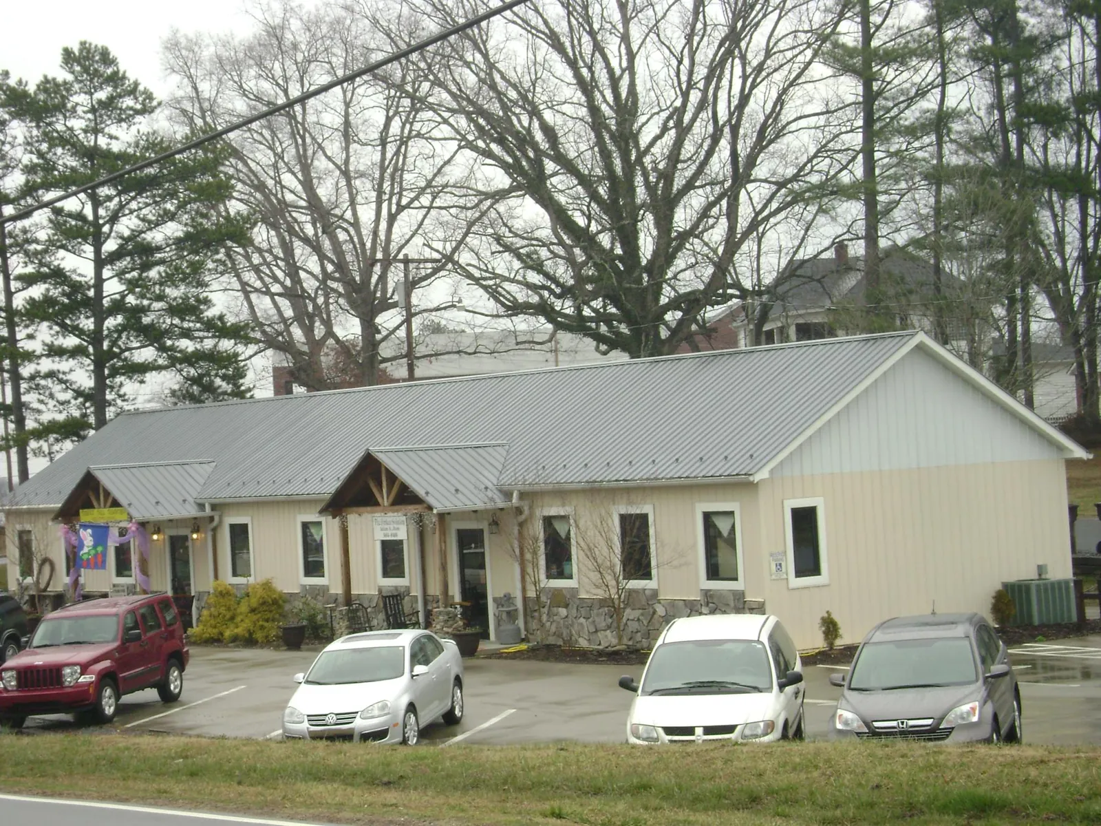 Gray metal roof with timber entry brackets on a small commercial building in New Woodstock