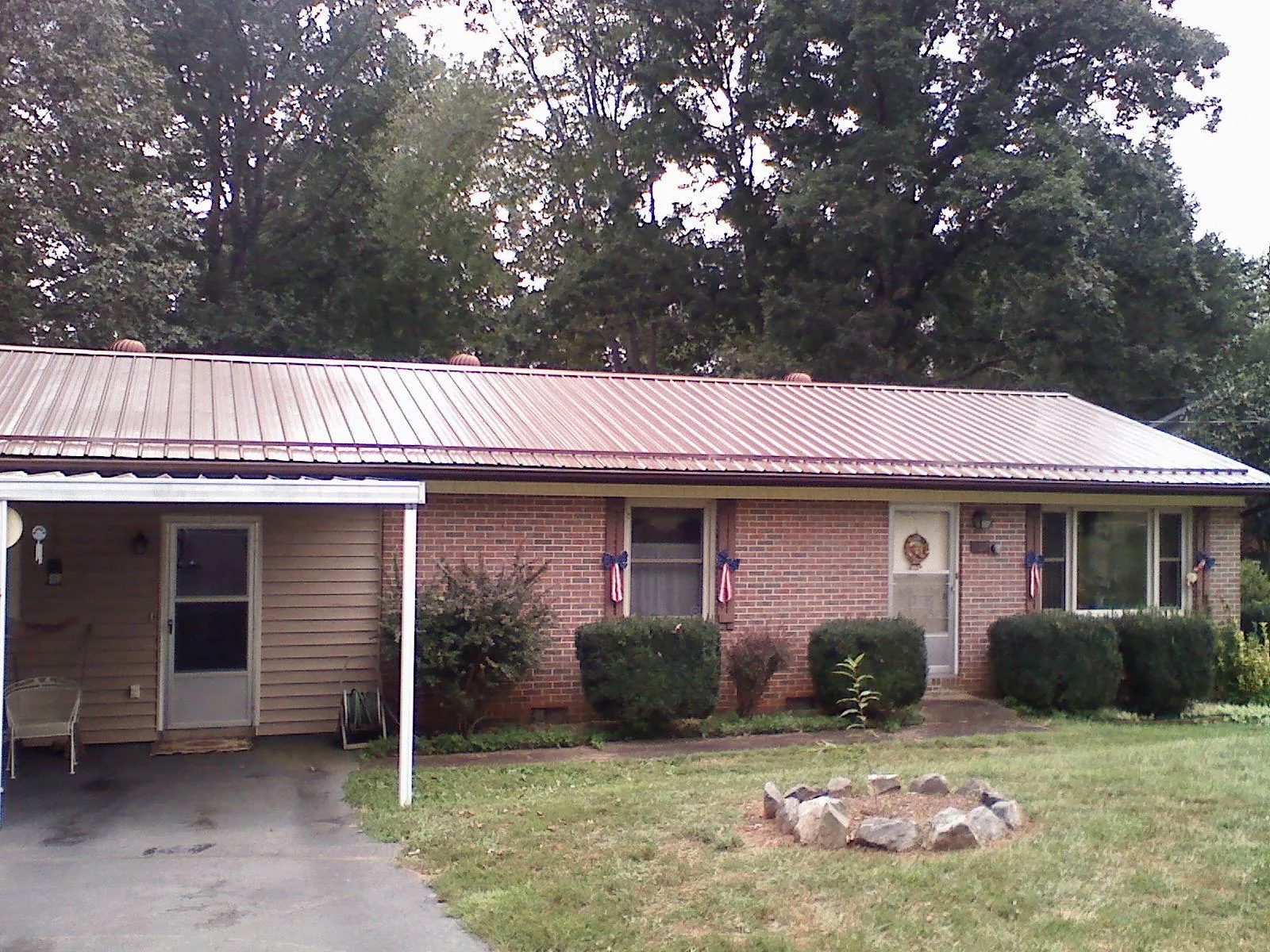 Bronze metal roof and carport on a brick ranch home — Roof Repair work by our crew in New Woodstock